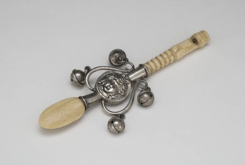 Children's rattle with decoration of a medallion with a woman's head