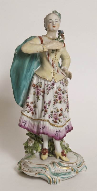 Figurin, flicka som lyfter en blomsterkvist