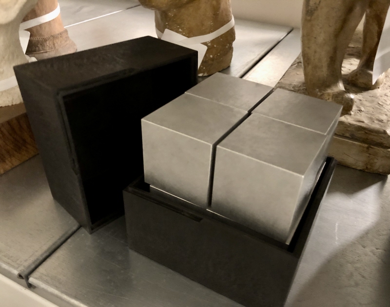 En kub med ett håll i form av en klot, i en svart låda