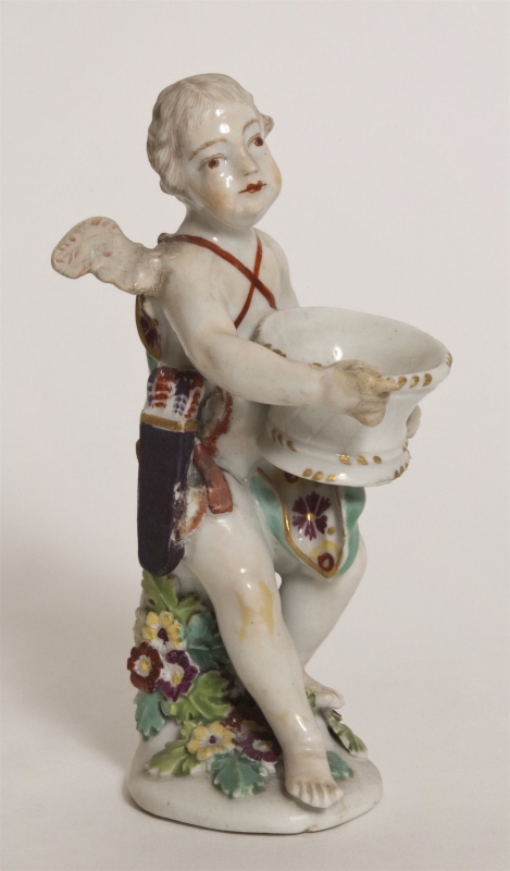 Figurin, på en stubbe sittande Cupido, bevingad