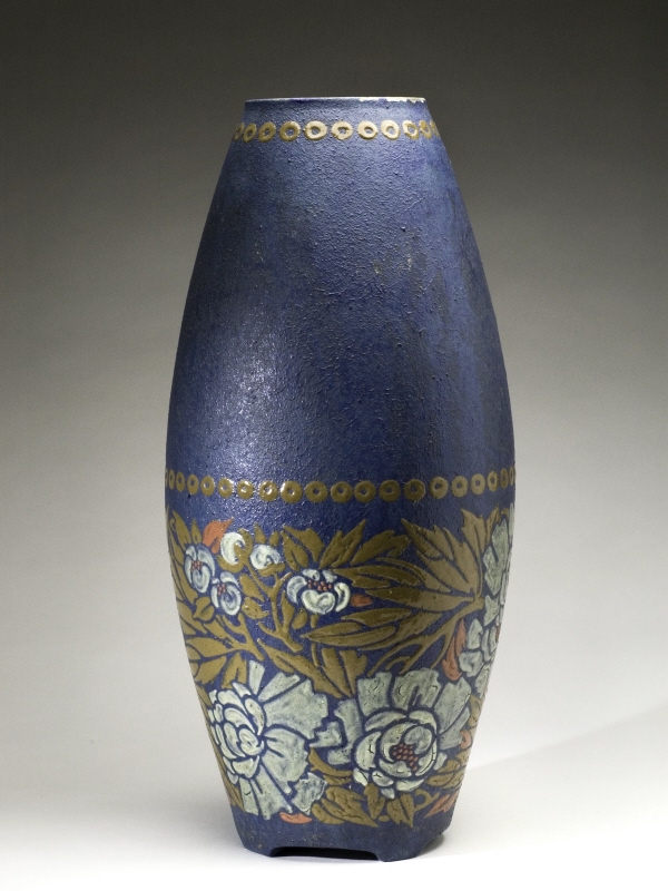 Spolformig vas med låga fötter, dekorband med stilliserade pioner i vitt och orange samt gula blad mot blå fond.